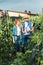 couple of smiling farmers checking harvest with clipboard in field