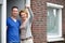 Couple smiling and holding keys to their new house