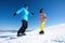 Couple snowboarding on snowy hill