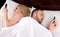 Couple socialising with mobile phones in bed