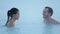 Couple Spa Retreat in Winter. Young woman and man enjoying romantic hot spa pool