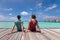 Couple spending romantic beach vacation holidays at luxurious resort in Maldives with turquoise sea water, blue sky and overwater