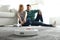 Couple spending time while robotic vacuum cleaner doing its work at home