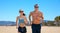 Couple in sports clothes running along on beach