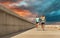 Couple in sports clothes running along pier