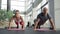 The couple of sportsmen does the push-ups on the mats in big bright luxury gym.