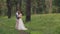 Couple standing arm in arm at wedding photo shoot in woods outdoors