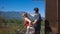 A couple is standing on the balcony embracing. Look on the mountain landscape