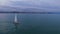 Couple standing at front end of sailing boat swimming against Batumi city line