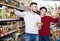 Couple standing near shelves with canned goods at store