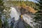 Couple standing on viewpoint bridge waterfall Tannforsen northern Sweden, rainbow in mist rapid flowing cascades water