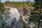 Couple standing on viewpoint bridge waterfall Tannforsen northern Sweden, rainbow in mist rapid flowing cascades water