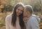 Couple stands in the forest together. Attractive girl hugging her boyfriend and looking at the camera. Happy family stay