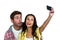 Couple sticking out tongue while taking selfie