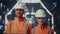 Couple successful factory engineer posing in modern facility in helmets closeup.