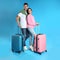 Couple with suitcases for summer trip on blue background. Vacation travel