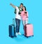 Couple with suitcases and tickets in passports for summer trip on blue background. Vacation travel