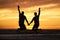 Couple, sunset and jump at beach while holding hands for happiness, bonding or romance on vacation. People, love and