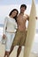 Couple With Surfboard On Beach