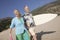 Couple with surfboard smiling on beach