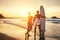 Couple surfers stay on sunset ocean beach