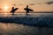 Couple of surfers walking on coastline at sunset