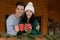 Couple in sweaters with cups near decorated railing