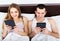 Couple with tablets in bedroom