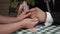 Couple takes each other`s hands sitting at a wooden table