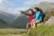 Couple taking a break after hiking uphill with man pointing