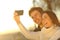 Couple taking selfie photo with a smart phone at sunset