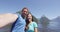 Couple taking selfie video having fun on travel in New Zealand, Milford Sound