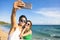 couple taking vacation selfie photograph at the beach