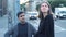 Couple talking standing on busy street. Media. Young man and woman talk on blurry background of evening traffic at