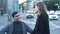 Couple talking standing on busy street. Media. Young man and woman talk on blurry background of evening traffic at