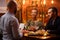 Couple talking to bartender behind bar counter in a cafe