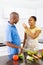 Couple tasting food in kitchen