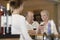 Couple Tasting Wine With Merchant In Foreground