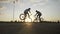 Couple of teen bikers doing high five while performing an amazing front wheelie on their bicycles -