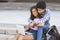 Couple of teenagers in love using laptop outdoors together