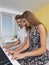 Couple of teenagers playing on the electronic piano