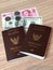 Couple Thai Passport with US dollar and Chinese money on the wood table for travel.