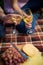 Couple toasting wineglasses by grapes and cheese on picnic blanket