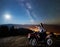 Couple tourists with atv quad bike under night starry sky