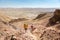 Couple tourists backpackers walking descending desert stone mou