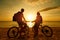 Couple tourists with Bicycles Watching Sunset. Silhouette people