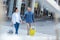 A couple of tourists crossing pedestrian with luggage while holding hands and looking