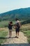 A couple of tourists in hats, a man with a backpack. walk against the backdrop of the mountains. Mtskheta. Georgia. Vertical photo