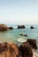 Couple tourists kayaking in tropical sea in the evening. Beautiful bay, stone, rocks and waves. Fishermen and sunset sky