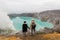 Couple tourists looks at the sulphur lake on the Ijen volcano on the island Java in Indonesia. Hikers travel on top